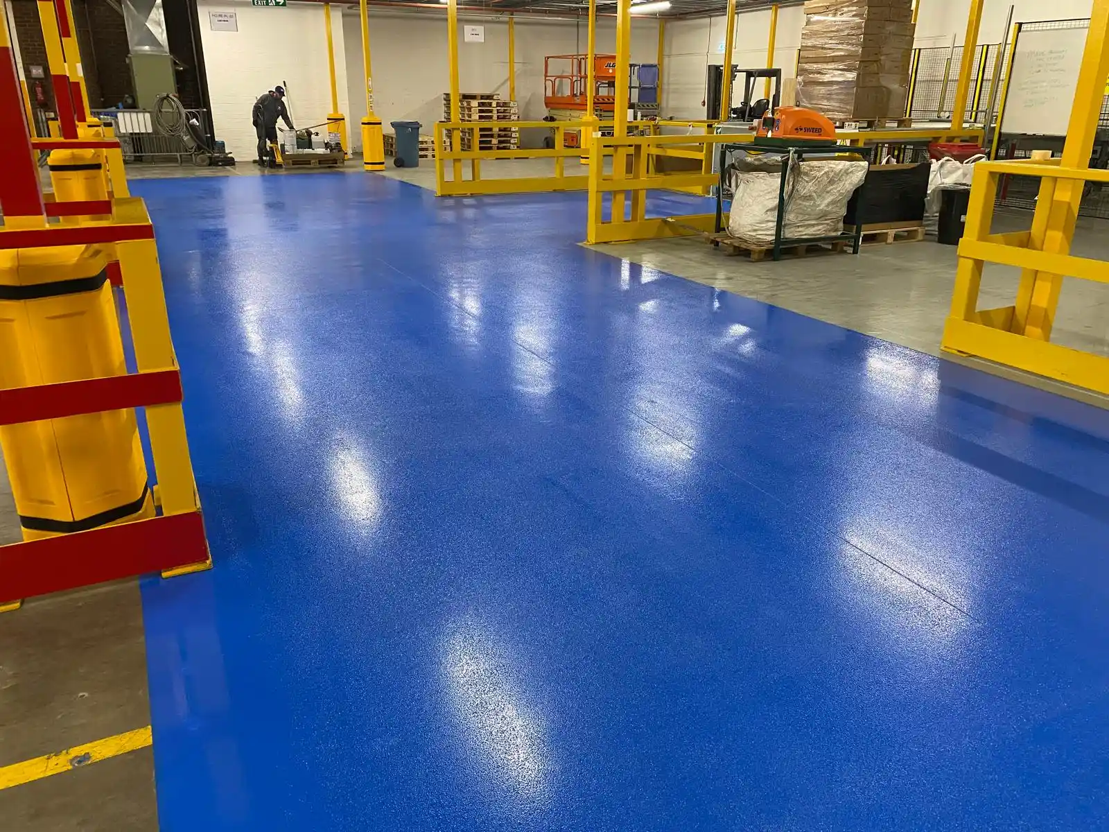 Industrial resin flooring contractors installing a heavy duty floor in a manufacturing plant