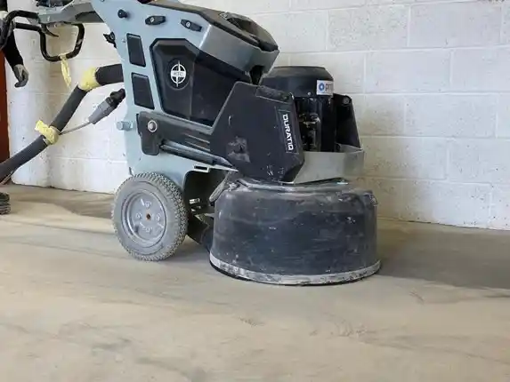 Flatbed diamond grinder carrying out concrete floor grinding before resin flooring